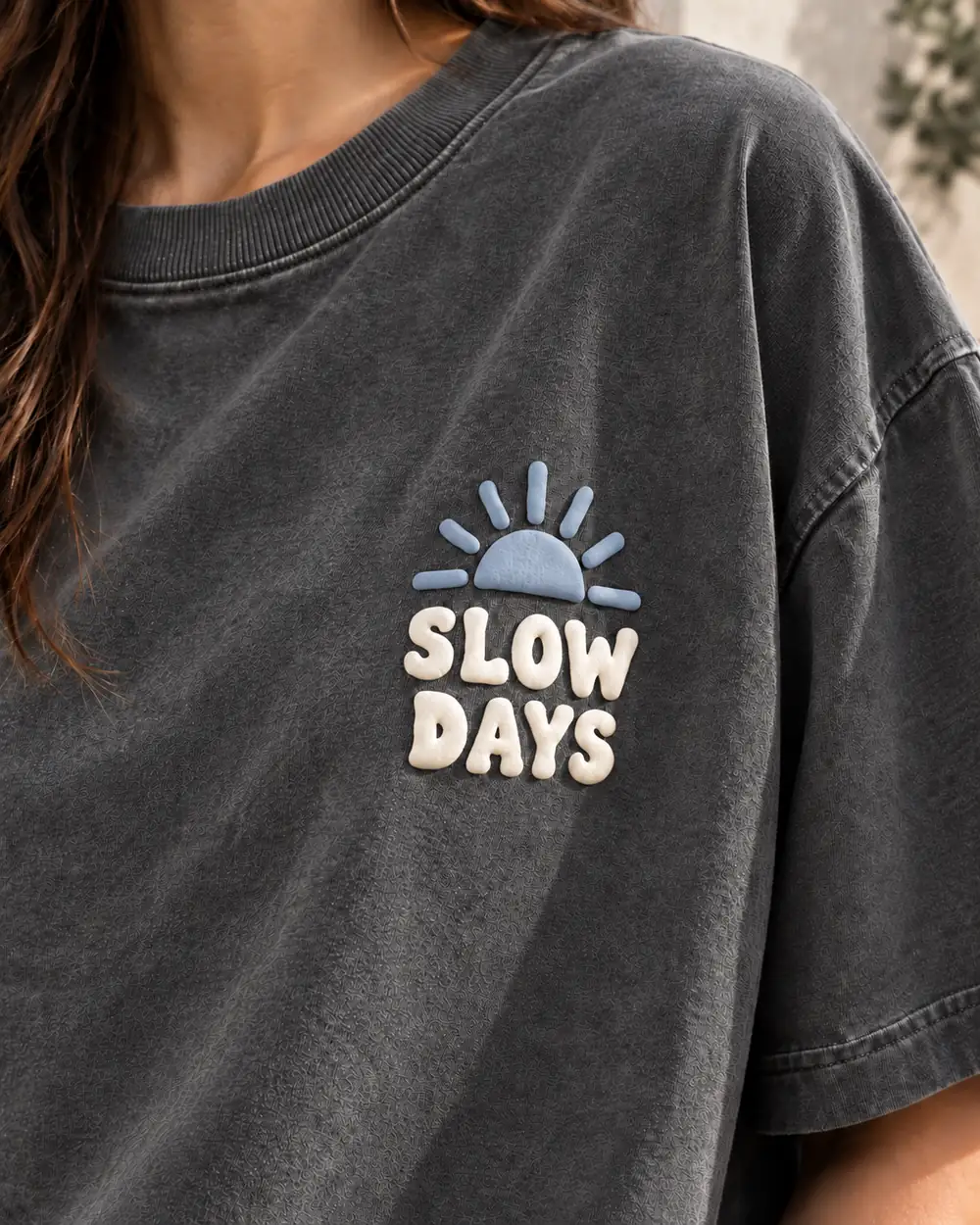 Close-up of two-color puff print graphic on washed charcoal T-shirt