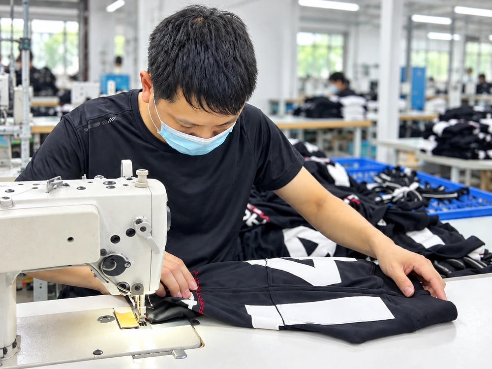 Sample sewing worker operating an industrial sewing machine in a garment factory