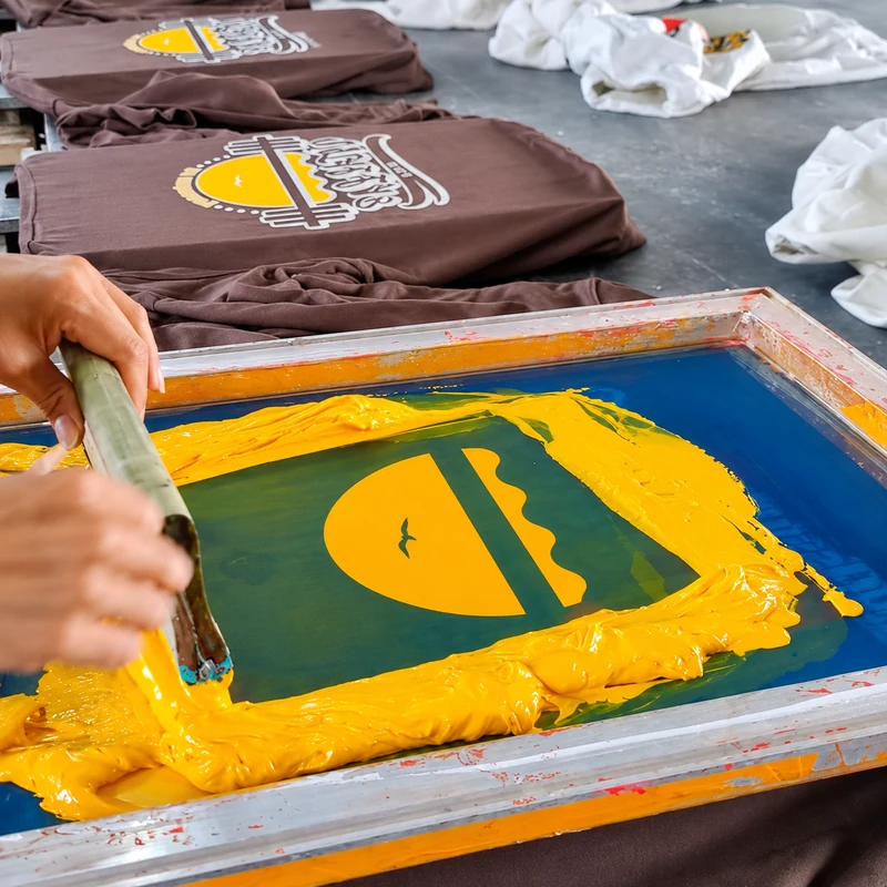 Yellow ink applied through a screen for T-shirt printing
